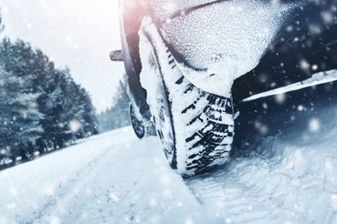 Auto ajaa lumisella tiellä